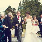 Bovey castle wedding photography of bride and groom walking through confetti shower hand in hand