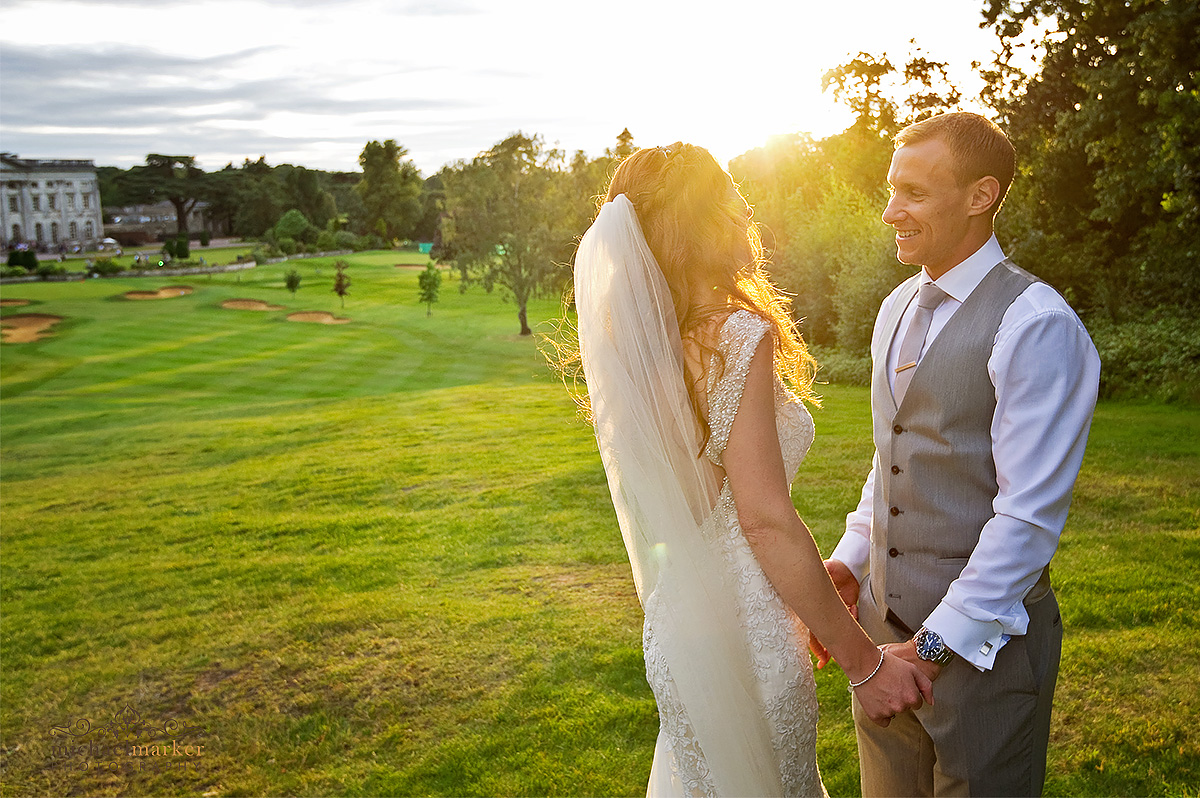 Bride and groom looking at each other at sunset with Moor Park in the background
