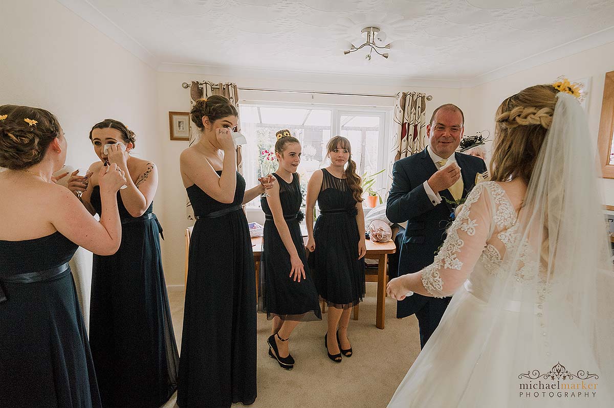 bridesmaids and father of bride crying when seeing bride for first time